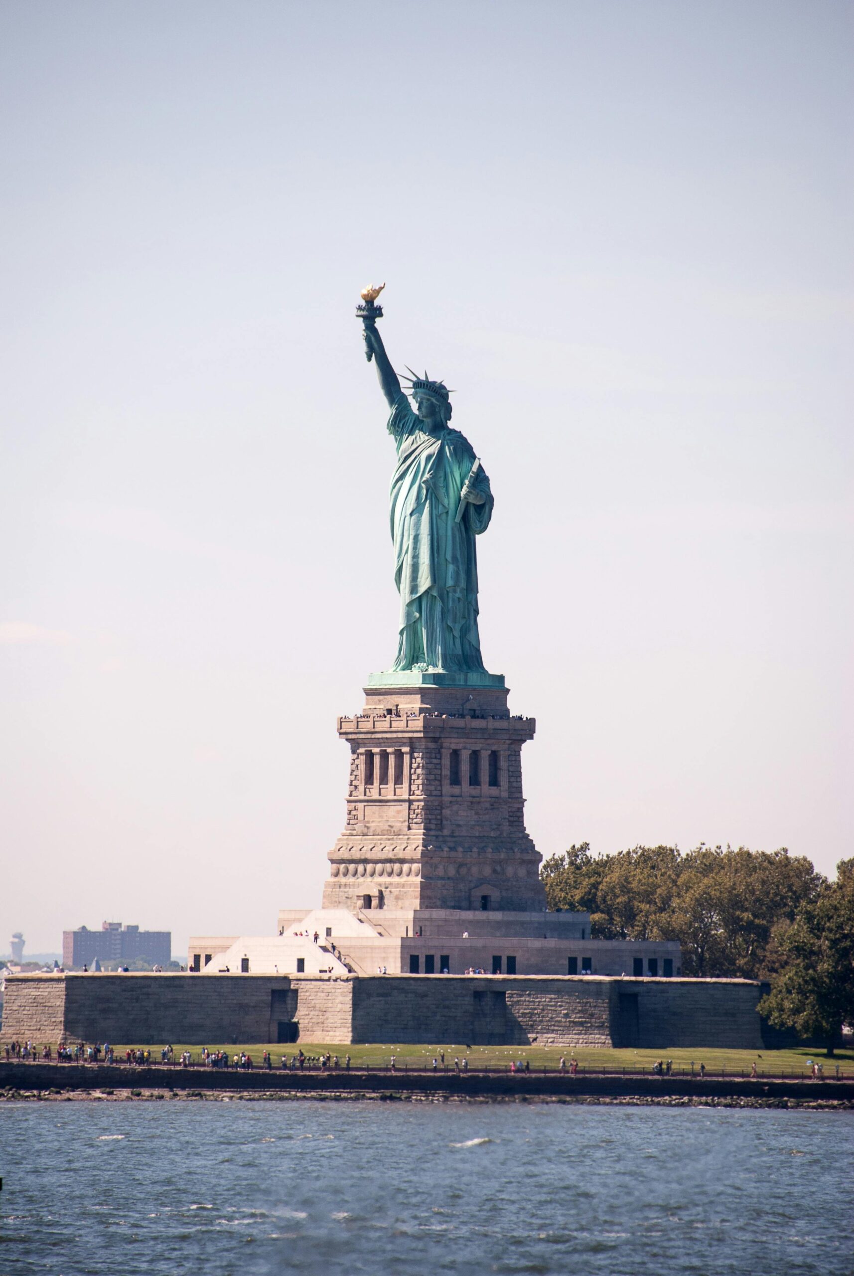The iconic Statue of Liberty standing proudly against a clear sky in New York City.